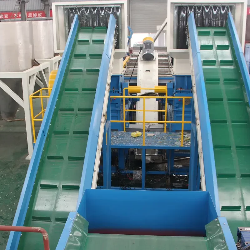 an operational scene within a plastic recycling facility, focusing on a series of conveyor belts used for transporting plastic materials through various stages of the recycling process. These conveyors are part of a larger system that likely includes sorting, cleaning, and shredding operations. The equipment is painted in vivid green and blue, enhancing visibility and safety within the industrial setting. In the background, there are various large tanks and machinery, possibly for washing or further processing the plastics. The setup shown is typical for facilities handling large volumes of recyclable materials, emphasizing efficient flow and processing to convert waste into reusable resources. Such facilities play a crucial role in environmental sustainability by reducing landfill use and providing recycled materials for new products.