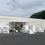 Warehouse with stacked white materials outside.